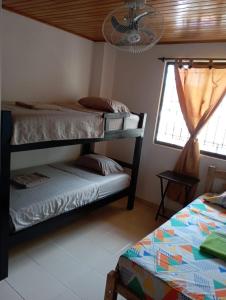 ein Schlafzimmer mit zwei Etagenbetten und einem Fenster in der Unterkunft Apartamento Hogar Caribeño 2H con AA in Santa Marta + 11 Fotos