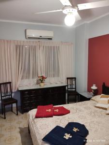 1 Schlafzimmer mit 2 Betten, 2 Stühlen und einem Fenster in der Unterkunft Dpto céntrico con estacionamiento in San Miguel de Tucumán