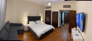 a hotel room with a bed and a couch at Marina Studio 2 in King Abdullah Economic City
