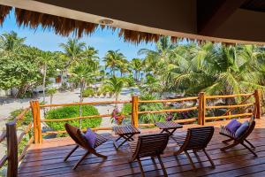eine Terrasse mit Stühlen und Strandblick in der Unterkunft La Perla del Caribe - Villa Amethyst in San Pedro