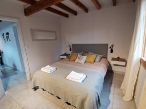 1 dormitorio con 1 cama grande y toallas. en Los Robles Patagonia en Esquel
