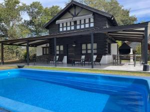 a house with a swimming pool in front of a house at Cabañas San Lorenzo in San Lorenzo