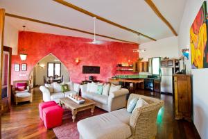 a living room with white furniture and a red wall at La Perla del Caribe - Villa Opal in San Pedro