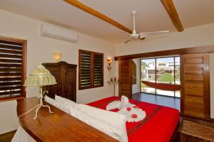 a bedroom with a bed with a red bedspread at La Perla del Caribe - Villa Opal in San Pedro +46 photos
