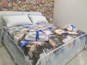 uma cama com um cobertor e dois bichos de peluche em Shine Flowers Room em Scordia