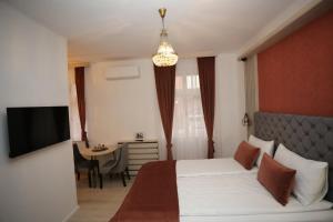 1 dormitorio con cama, mesa y TV en Apartments Artee Free Garage Parking, en Sarajevo