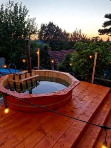 un pequeño barco sentado en una terraza de madera en Vila cu Ciubar & Jacuzzi - Sunset Hill House, en Cuvin