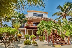 a house on the beach with palm trees in front of it at La Perla del Caribe - Villa Jade in San Pedro
