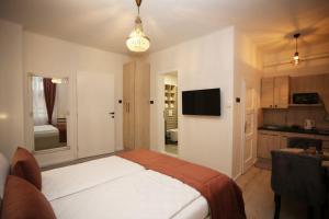 a bedroom with a large bed and a kitchen at Apartments Artee Free Garage Parking in Sarajevo