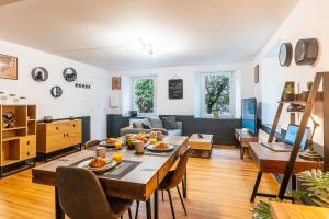 een eetkamer en een woonkamer met een tafel en stoelen bij Le 18-GregIMMO-Appart'Hôtel in Bavilliers