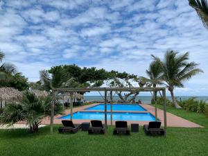 a swimming pool with chairs and a gazebo at Mar De Estrellas - Hotel in Costa Esmeralda