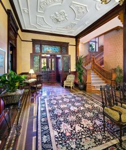 a living room with a staircase and a rug at Wentworth Mansion in Charleston
