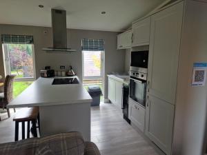 a kitchen with white cabinets and a counter top at Derwen 2 Bedroom Luxury Lodge in Welshpool