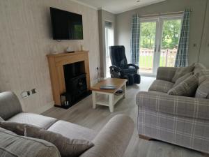 a living room with two couches and a chair at Derwen 2 Bedroom Luxury Lodge in Welshpool