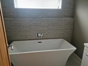 a white bath tub in a bathroom with a window at Luxury Lodge - Sleeps 4 hot tub & parking in Welshpool
