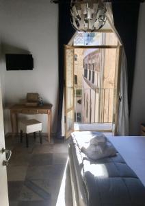 サレルノにあるB&B Palazzo Fruscioneのベッドルーム1室(ベッド1台、窓、テーブル付)