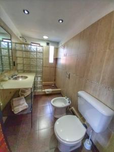 La salle de bains est pourvue de toilettes blanches et d'un lavabo. dans l'établissement Cabañas San Lorenzo, à San Lorenzo