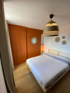 a bedroom with a bed and a pendant light at Cristal 1 in Issoire