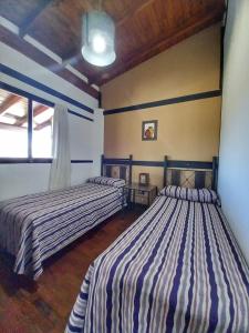 two beds sitting in a room with at Cabañas San Lorenzo in San Lorenzo