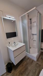 a white bathroom with a sink and a shower at Cristal 1 in Issoire