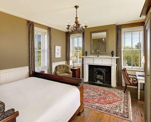 a bedroom with a bed and a fireplace at Wentworth Mansion in Charleston