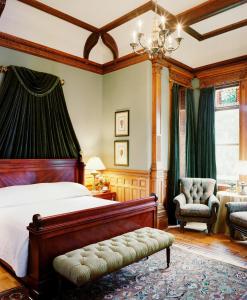 a bedroom with a bed and a chair and a window at Wentworth Mansion in Charleston