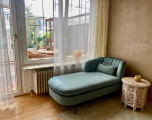 einen grünen Stuhl in einem Zimmer mit Fenster in der Unterkunft Ferienwohnung Louise 50 m zum See in Kressbronn am Bodensee