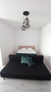 a bedroom with a black bed and a chandelier at Lovely Sunrise in Bucharest
