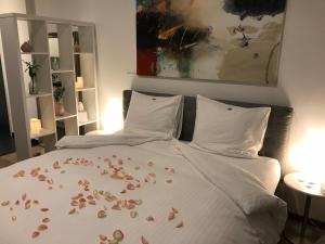 a bed with flower petals on the sheets at Antwerp Business Suites in Antwerp