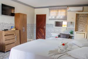 a bedroom with a large white bed and a television at Viana Palace Hotel in Juazeiro do Norte