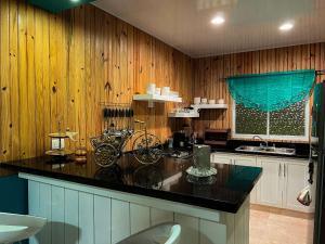uma cozinha com paredes de madeira e uma bancada preta em Alaia Casa de campo By Hospedify Para 4 personas, cerca del Río, Naturaleza, BBQ y terraza familiar em Jarabacoa