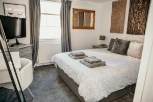 a bedroom with a bed with towels on it at Seatown, beautiful townhouse in central Weymouth in Weymouth