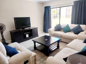 キンバリーにある2-bedroom apartment in a security complexのリビングルーム(ソファ、テレビ、テーブル付)