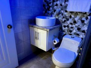 a blue bathroom with a sink and a toilet at Alaia Casa Campo By Hospedify, Propiedad de Lujo para 6, cerca de la naturaleza y el Río in Jarabacoa