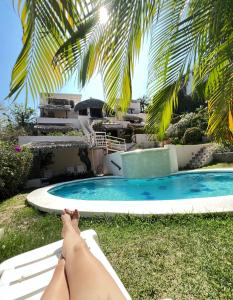 Agua Azul la Villa في سانتا كروز هواتولكو: وضع امرأة على أرجوحة بجوار حمام السباحة