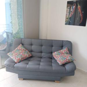 un sofá con 2 almohadas en la sala de estar en Condominio Terrazas del Sol, en Sopetrán