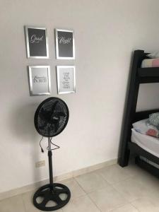 un ventilador en una habitación con fotos en la pared en Condominio Terrazas del Sol, en Sopetrán