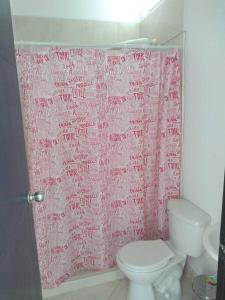 cortina de ducha rosa en el baño con aseo en Condominio Terrazas del Sol, en Sopetrán