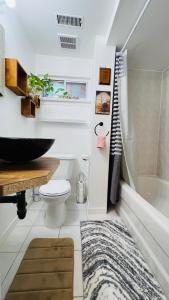 een badkamer met een bad, een toilet en een wastafel bij Sunrise Tree BnB - your Home away from home in Toronto