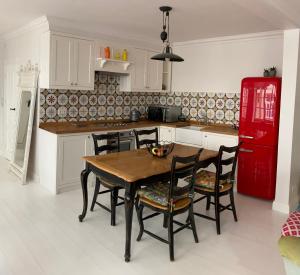 a kitchen with a wooden table and chairs and a red refrigerator at Shabby Chic - apartment in the Heart of Vilnius Old Town in Vilnius