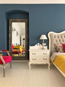 a bedroom with a mirror and a bed and a chair at Shabby Chic - apartment in the Heart of Vilnius Old Town in Vilnius