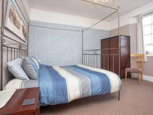 a bedroom with a bed and a table and a chair at Glenthorne Villa Torquay in Torquay