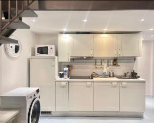 een keuken met witte kasten en een magnetron bij LaFilo Apartment 2 in Milaan