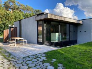 a modern house with a deck and a table at Shelter in Zutendaal