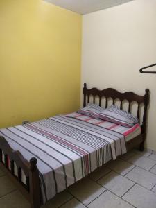 1 dormitorio con 1 cama en una habitación con paredes amarillas en Kitnets Plus en São Carlos
