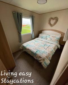 a small bedroom with a bed and a window at Living Easy Staycations at Tattershall Lakes in Tattershall