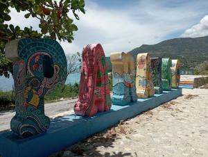 una fila de botas coloridas sentadas en una acera en Lugar encantador en el Malecón Paraíso, Barahona., en Paraíso