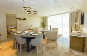 a dining room with a table and chairs and a living room at Five Palm Jumeirah Suites-Sea View in Dubai