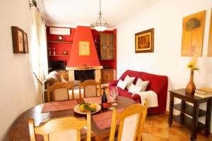 アルゴドナレスにあるCasa Rural Los Niñosのリビングルーム(テーブル、赤いソファ付)