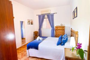 a bedroom with a blue and white bed and a dresser at Casa Rural Los Niños in Algodonales